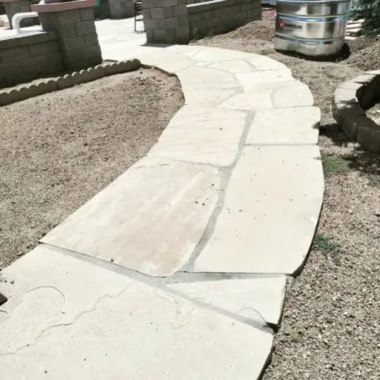 Pathway made of stone slabs winding through a landscaped outdoor area.