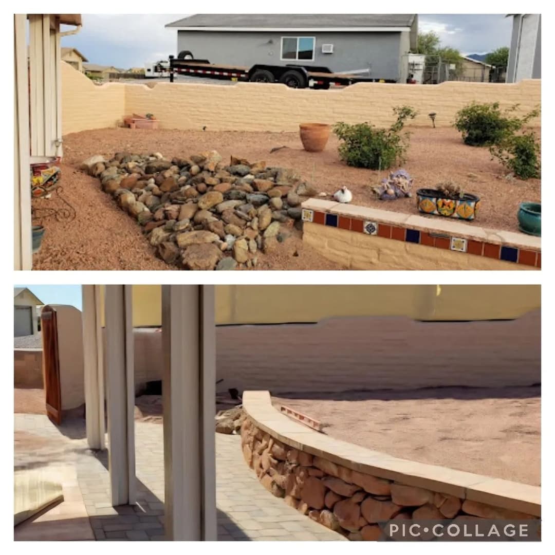 Desert garden with rock landscaping and a patio area, featuring colorful pots and a wall.